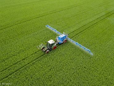 mezőgazdasági jármű halad keresztül a zöldellő földön