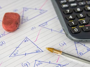 Egy gyermek geometria házi feladata számológéppel, tollal és radírral