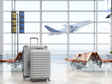 Reptéri váróteremben egy bőrönd, háttérben repülőgép felszáll
