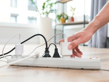 Man plugging the power plug. Electrical plug in outlet socket at home.