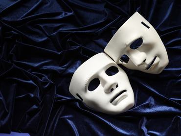 Theater arts. White masks on blue fabric, above view. Space for text