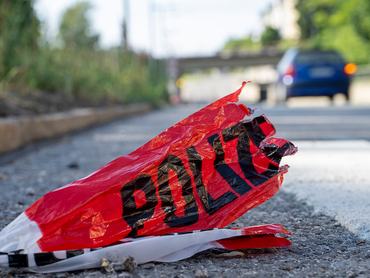 rendőrségi szalag maradéka az aszfalton a távolban egy autó halad