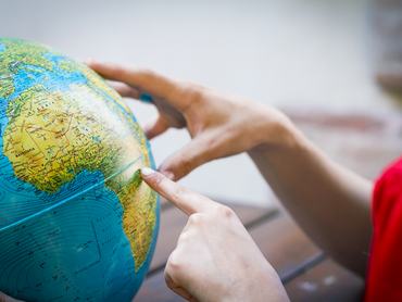 Egy fiatal Afrikára mutat a földgömbön.