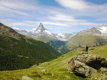 Női túrázó egy sziklán állva a Matterhornnal szemben, a svájci Alpokban.