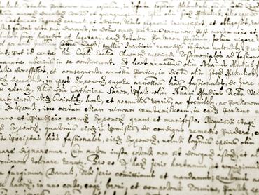 Detail of an old medieval manuscript in sepia, shallow depth of field