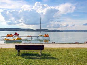Balatoni strand a parton paddal a vízben vízibicklivel
