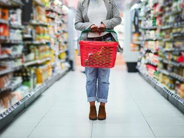 Nő, élelmiszer-szupermarket és kosár a kezében élelmiszerek, kiskereskedelmi és ipari áruk vásárlásához. Vásárló a szupermarketben, bevásárlás a kisboltban, valamint akciós, kedvezményes vagy leárazott termékek vásárlása