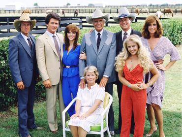 A „Dallas” című amerikai televíziós sorozat egyik promóciós fotója a szereplőgárdát ábrázolja a texasi Dallas külvárosában található Southfork-ranch területén, 1979-ben. Balról jobbra: az amerikai színészek Steve Kanaly (Ray Krebbs szerepében), Patrick Duffy (Bobby Ewing szerepében), Victoria Principal (Pamels Barnes Ewing szerepében), (ülve), Barbara Bel Geddes (Eleanor Southworth „Miss Ellie” Ewing szerepében), Jim Davis (1909–1981) (John Ross „Jock” Ewing szerepében), Larry Hagman (John Ross „J.R.” Ewing, Jr. szerepében), Charlene Tilton (Lucy Ewing szerepében) (piros ruhában) és Linda Gray (Sue Ellen Ewing szerepében). (Fotó: CBS Photo Archive/Getty Images)