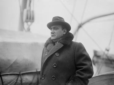 Enrico Caruso, 1910-1915 körül kabátban és kalapban elmosódott háttér előtt
