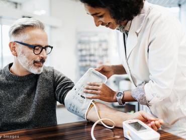 Idősebb férfi vérnyomását méri egy doktornő