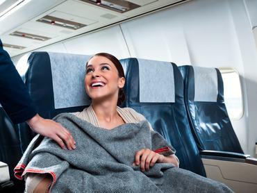 egy utas betakarózik a repülőn