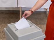 női kéz szavazólapot dob be egy szavazóurnába a magyar választásokon