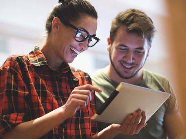 Egy férfi és egy nő tableten netezik