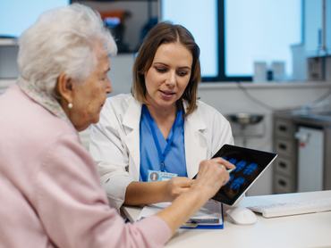 Orvos magyarázza az idősebb betegnek az agyi MRI-vizsgálat eredményeit. Betegségek diagnosztizálása idős embereknél. Agyvizsgálat, stroke, demencia, fejsérülések vagy idegrendszeri rendellenességek felismerése.