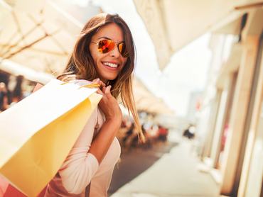 Vásárló nő. Boldog nő bevásárlószatyrokkal, aki élvezi a vásárlást. Fogyasztói kultúra, vásárlás, életmódkoncepció