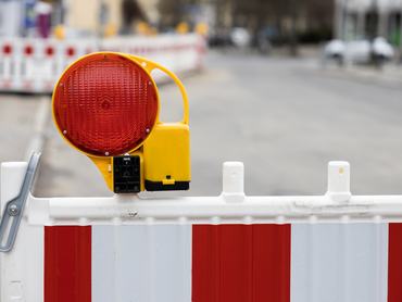 Útlezárásra figyelmeztető kerítés és lámpa egy utcai építkezésen